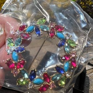 Holiday pin  with multi jewels pink, green, turquoise, in a gold setting.